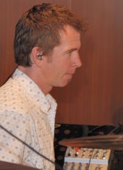 The drummer looks on